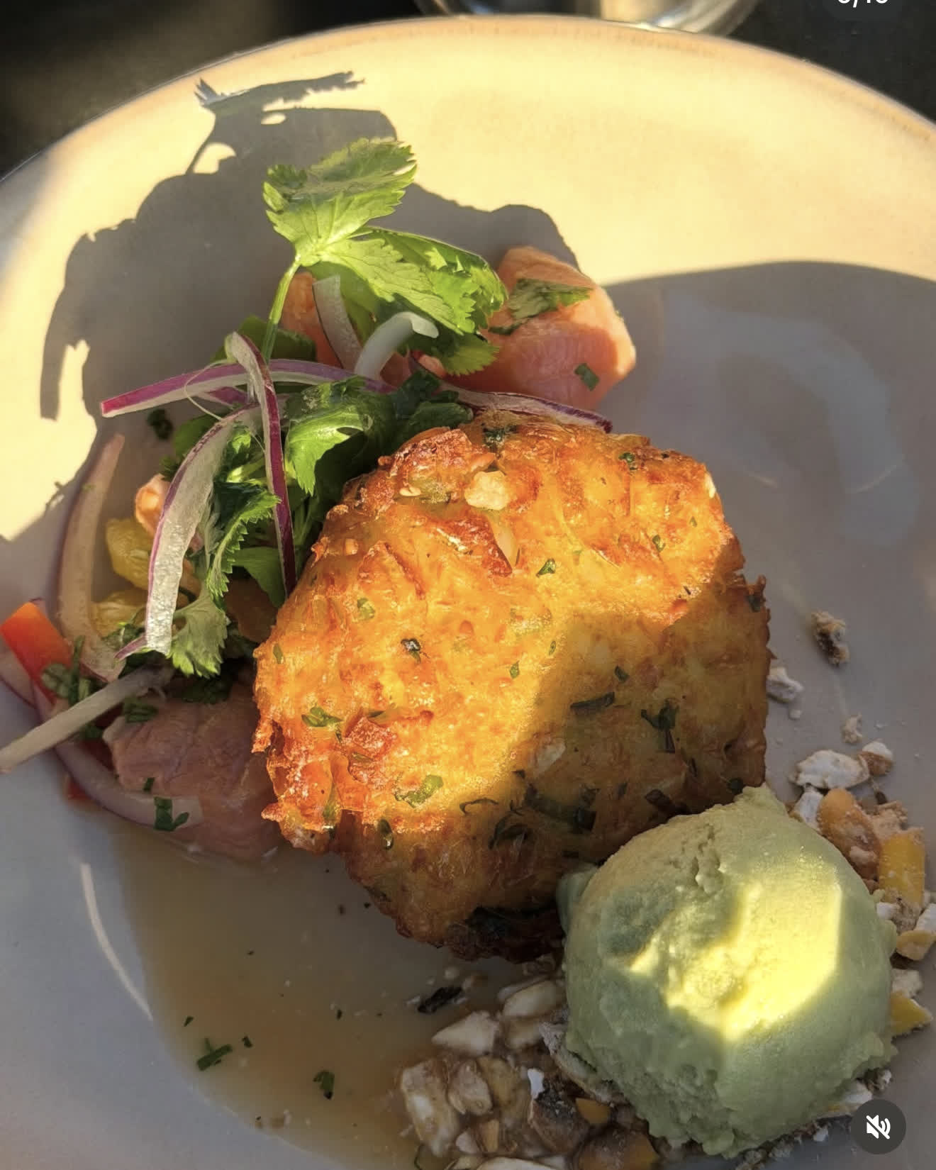 A plated fritter with salsa criolla and avocado mousse