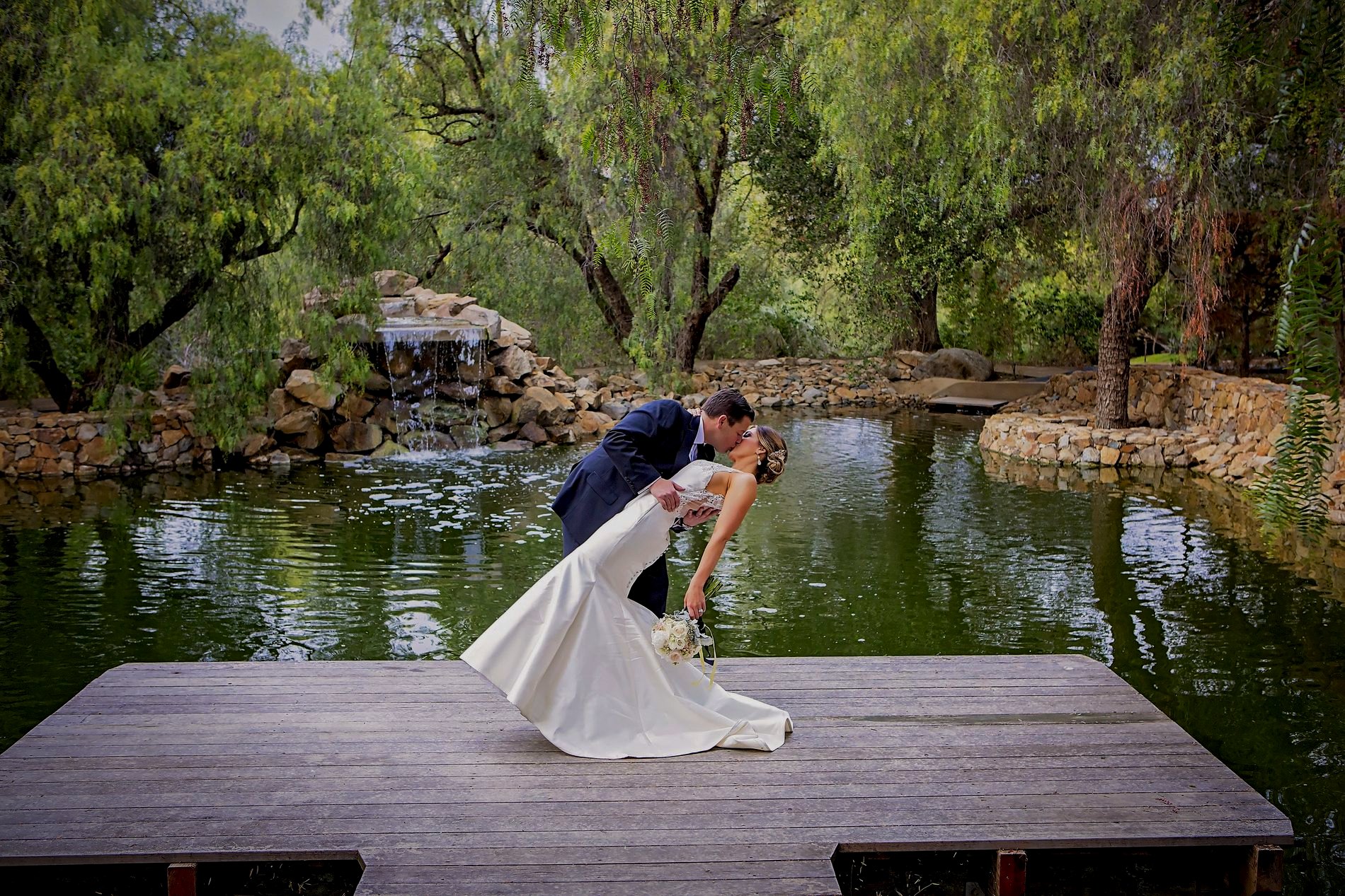 A couple at their Hill Top Winery wedding at the vineyard pond
