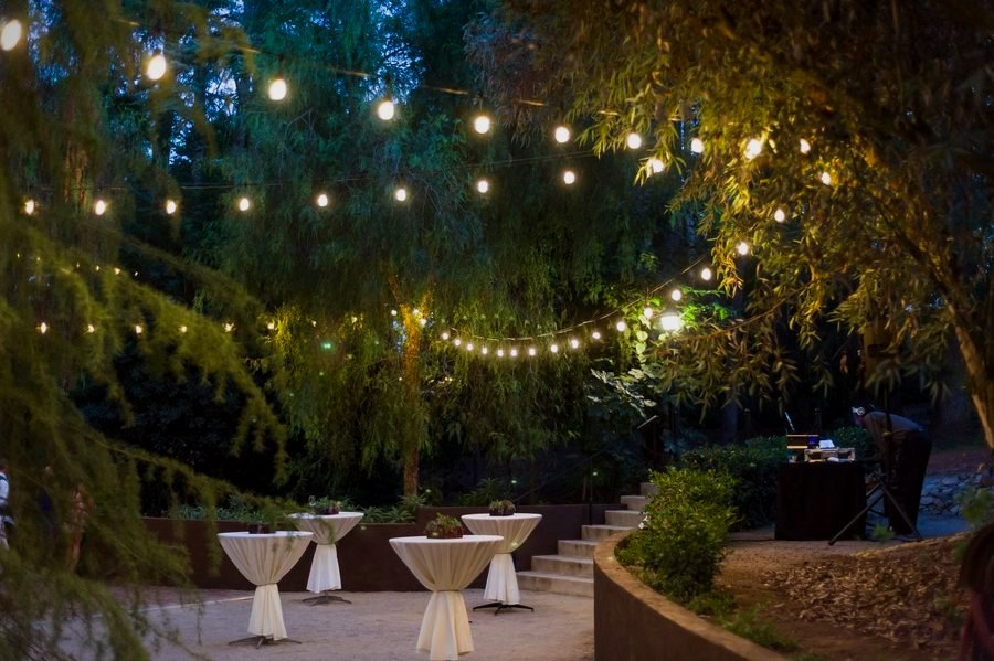 A cocktail reception under string lights at dusk