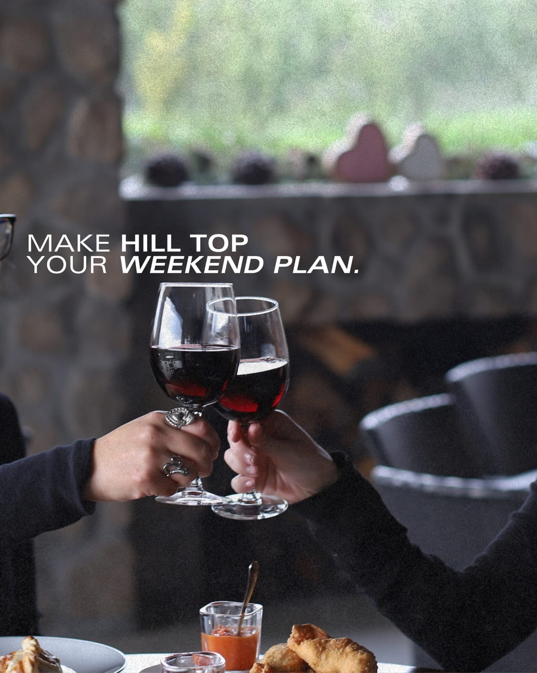 Two glasses of red wine raised in a toast at Hill Top